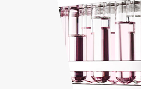 Vasos de precipitación llenos con líquido rosa claro para representar la investigación y el desarrollo de Mary Kay en el campo de los cosméticos.