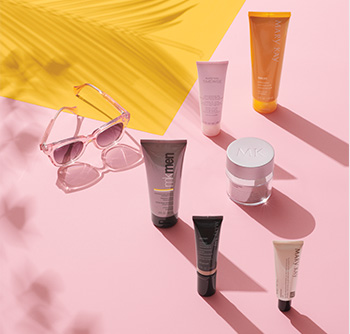 Various Mary Kay® skin care products and body care products with SPF sunscreen and sunglasses on a pink and yellow background 