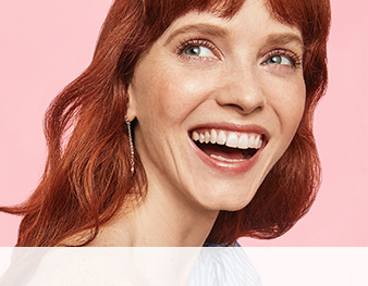 A redhead with bangs in a natural makeup look