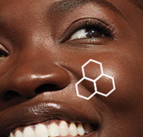 Up close macro image of a smiling African-American woman with brown eyes with an outline of the TimeWise 3D® Complex on her cheek