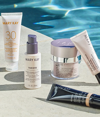 Imagen de varios productos del cuidado de la piel y cuerpo Mary Kay® con FPS y unas gafas de sol contra un fondo de color rosa y amarillo 